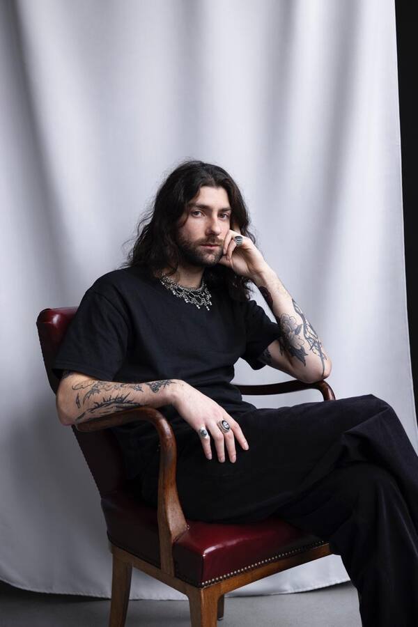 Maxime assis dans un fauteuil de cuir rouge