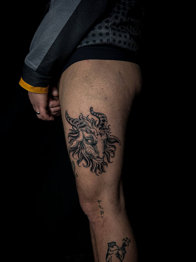 Tête de bouc cornue, tatouée sur une cuisse