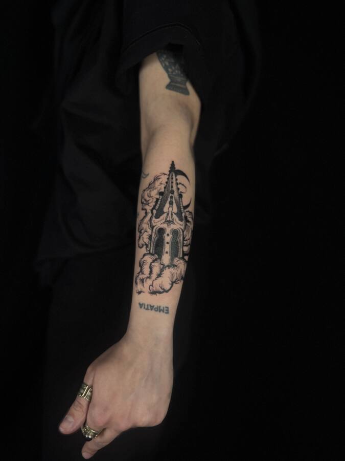 Cathédrale dans les nuages, tatouée sur un avant-bras