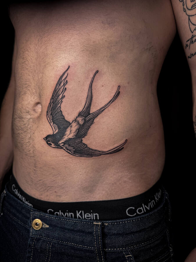Hirondelle tatouée sur le flanc