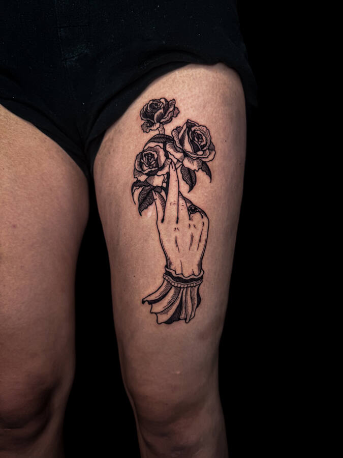 Main tenant des roses, tatouée sur une cuisse