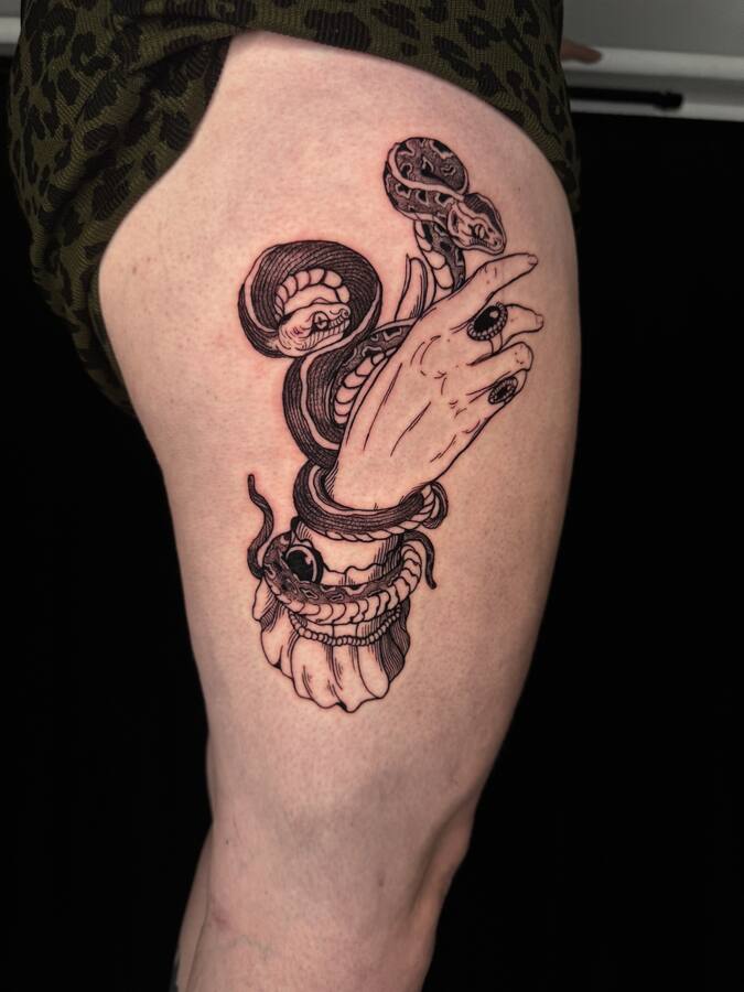 Le serpent et la main tatoués sur une cuisse, cicatrisés