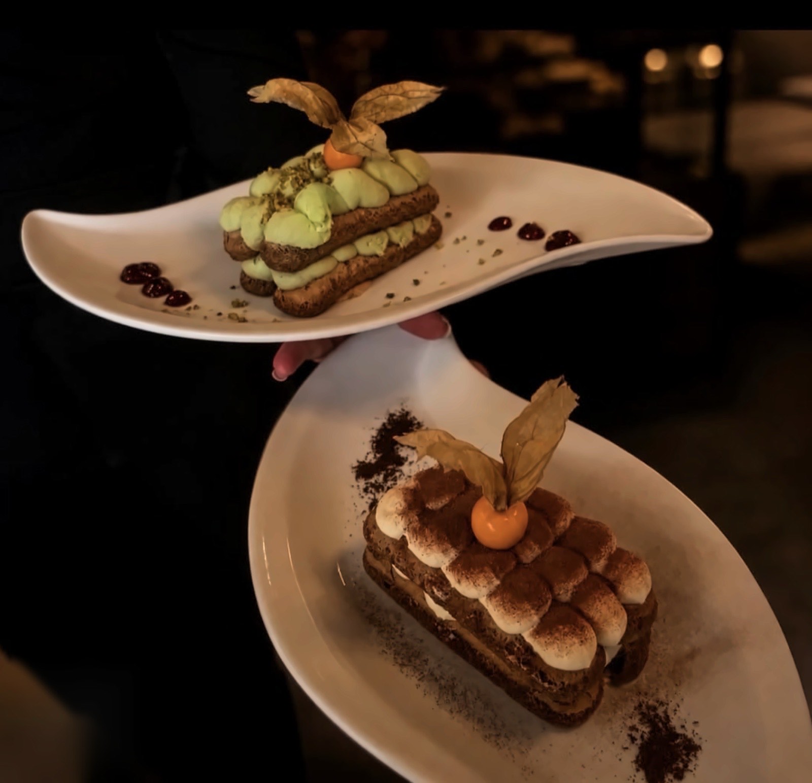 Deux desserts maison portés en salle : tiramisu et mille-feuille à la pistache