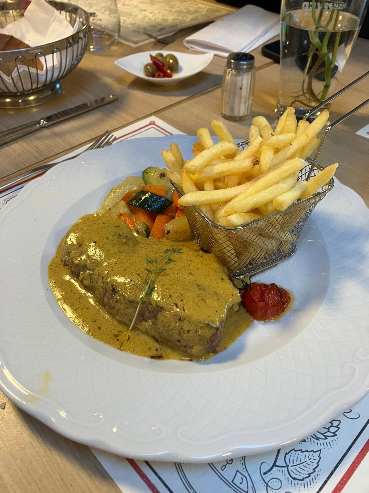 Entrecôte au Café de Paris et frites maison, servie sur la nappe du club