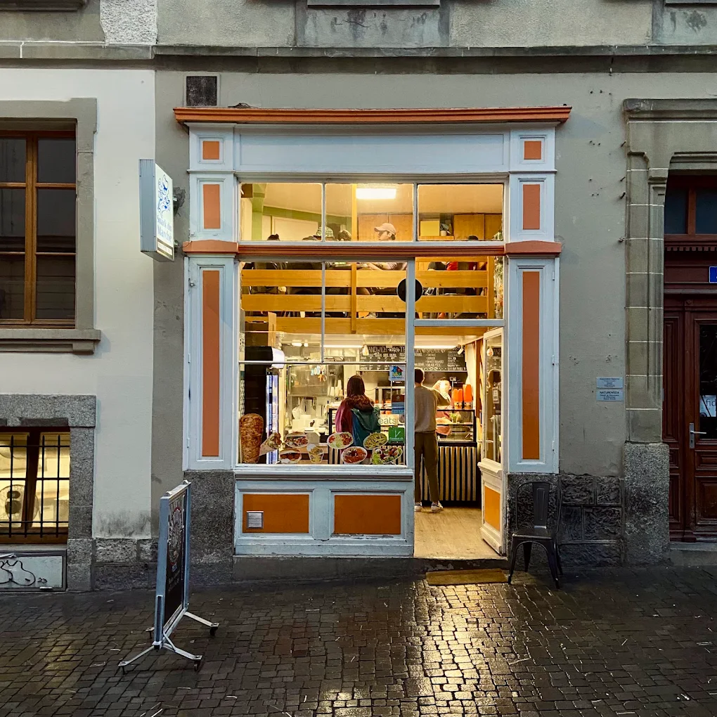 La devanture éclairée du Snack du Marché à la nuit tombée